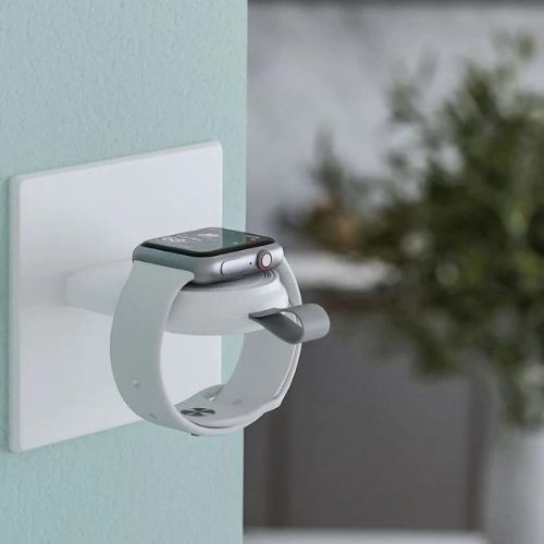 Smartwatch charging stand with a smartwatch on a light blue wall background