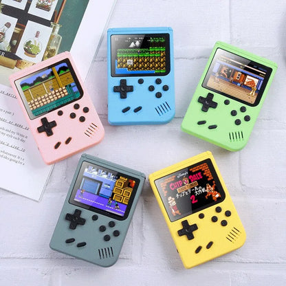 Five colorful handheld games consoles on a light surface with visible text and images.