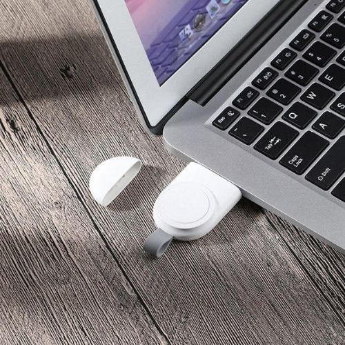 White USB drive attached to a laptop on a wooden surface