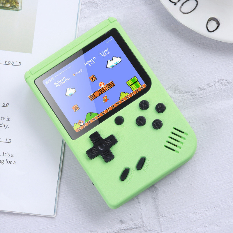 Green handheld game console with a classic game displayed on the screen, placed on a light surface.