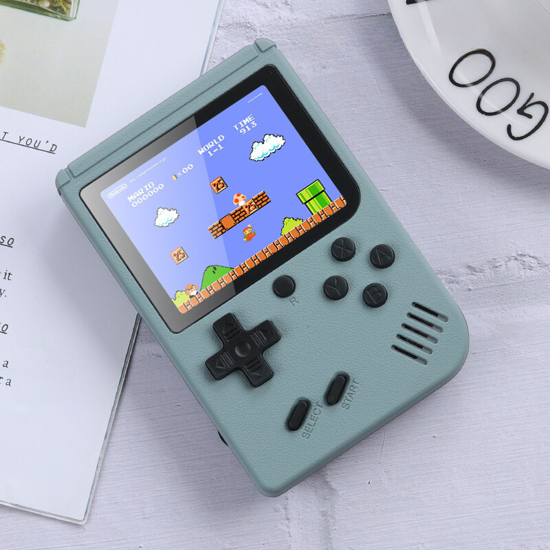 Handheld game console with a classic game displayed on the screen, placed on a light surface.