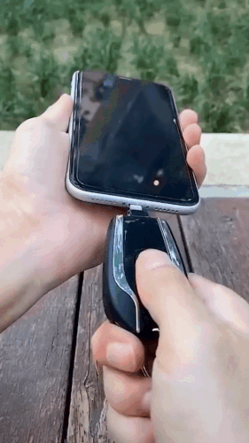 car shaped phone powerbank with keychain attachment plugging into phone to show charging state